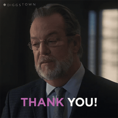 A Man In A Suit And Tie Is Giving A Thank You Sign GIF