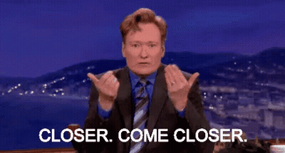 A Man In A Suit And Tie Is Giving A Thumbs Up And Says Closer Come Closer . GIF