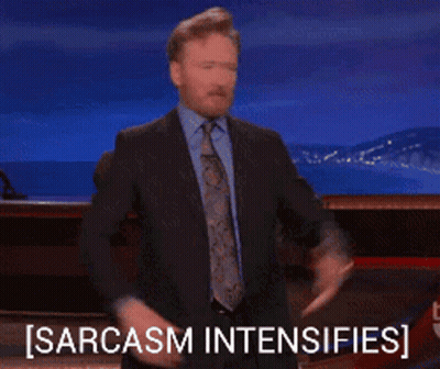 A Man In A Suit And Tie Is Giving A Thumbs Up And The Words Sarcasm Intensifies Behind Him GIF