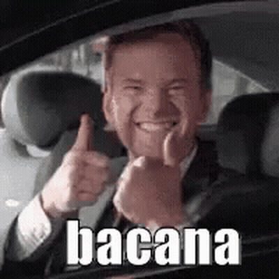 A Man In A Suit And Tie Is Giving A Thumbs Up While Sitting In A Car . GIF