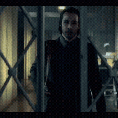 A Man In A Suit And Tie Is Holding A Bloody Knife In His Hand GIF