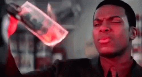A Man In A Suit And Tie Is Holding A Bottle Of Vodka And A Piece Of Money In His Hand . GIF