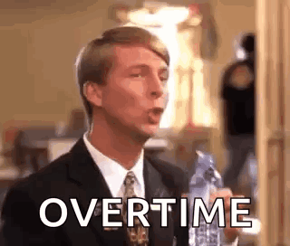 A Man In A Suit And Tie Is Holding A Bottle Of Water In His Hand . GIF