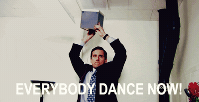 A Man In A Suit And Tie Is Holding A Box Over His Head With The Words " Everybody Dance Now " Above Him GIF