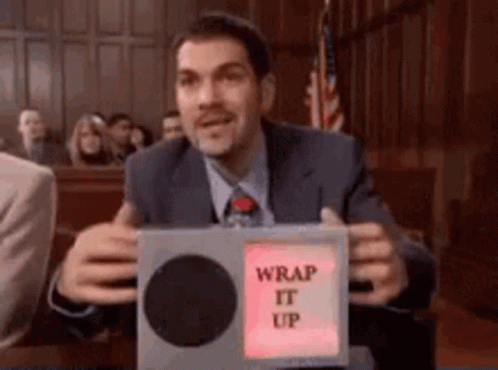 A Man In A Suit And Tie Is Holding A Box That Says Wrap It Up GIF