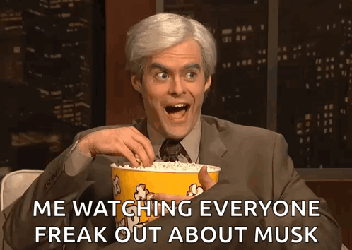 A Man In A Suit And Tie Is Holding A Bucket Of Popcorn And Says Me Watching Everyone Freak Out About Musk GIF