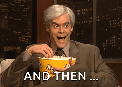 A Man In A Suit And Tie Is Holding A Bucket Of Popcorn And Then GIF