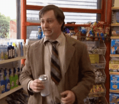 A Man In A Suit And Tie Is Holding A Can Of Soda GIF