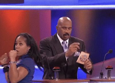 A Man In A Suit And Tie Is Holding A Card That Says ' I 'M Hungry ' On It GIF