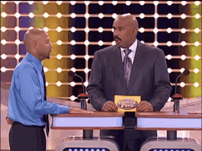 A Man In A Suit And Tie Is Holding A Card That Says ' The Price Is Right ' On It GIF