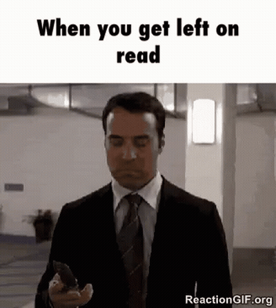 A Man In A Suit And Tie Is Holding A Cell Phone And Looking At It . GIF