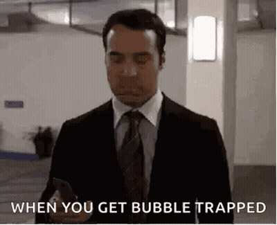 A Man In A Suit And Tie Is Holding A Cell Phone And Saying `` When You Get Bubble Trapped '' . GIF