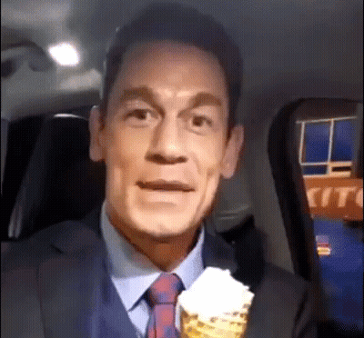 A Man In A Suit And Tie Is Holding A Cone Of Ice Cream . GIF