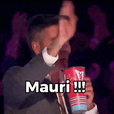 A Man In A Suit And Tie Is Holding A Cup That Says Mauri !!! GIF