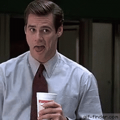 A Man In A Suit And Tie Is Holding A Cup With A Smiley Face On It GIF