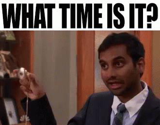 A Man In A Suit And Tie Is Holding A Donut And Asking What Time Is It . GIF