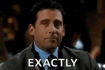A Man In A Suit And Tie Is Holding A Drink And Making A Funny Face . GIF