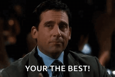 A Man In A Suit And Tie Is Holding A Drink And Pointing At The Camera With The Words `` Your The Best '' . GIF