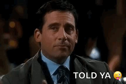 A Man In A Suit And Tie Is Holding A Drink In His Hand And Making A Funny Face . GIF
