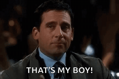 A Man In A Suit And Tie Is Holding A Drink In His Hand And Saying `` That 'S My Boy '' . GIF
