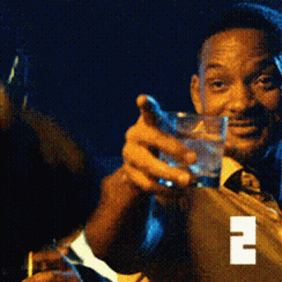 A Man In A Suit And Tie Is Holding A Glass Of Water And A Cigarette GIF