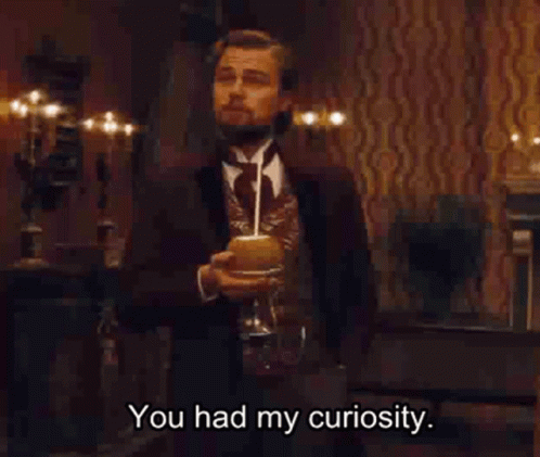 A Man In A Suit And Tie Is Holding A Glass Of Wine And Saying You Had My Curiosity GIF