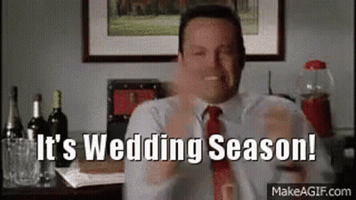 A Man In A Suit And Tie Is Holding A Glass Of Wine And Says `` It 'S Wedding Season ! '' GIF