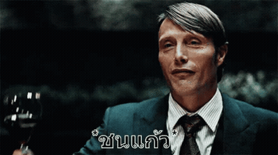 A Man In A Suit And Tie Is Holding A Glass Of Wine In His Hand GIF