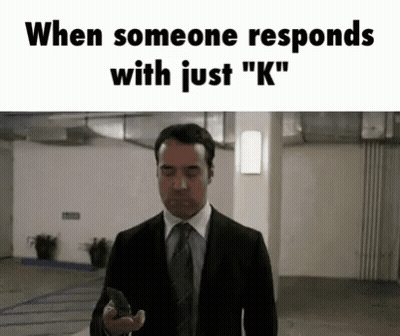 A Man In A Suit And Tie Is Holding A Gun In A Garage . GIF