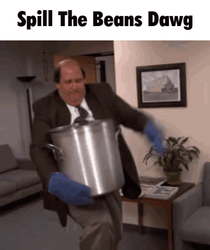 A Man In A Suit And Tie Is Holding A Large Pot That Says Spill The Beans Dawg On The Bottom GIF