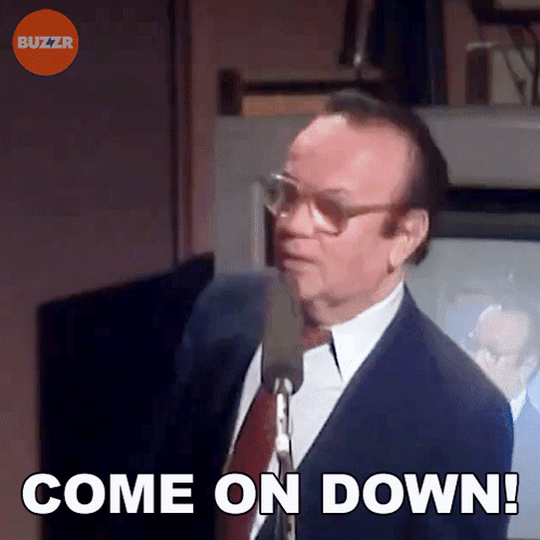 A Man In A Suit And Tie Is Holding A Microphone And Saying Come On Down GIF