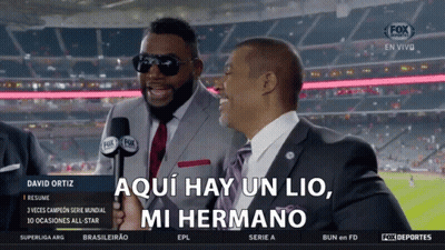 A Man In A Suit And Tie Is Holding A Microphone And Says Aqui Hay Un Lio Mi Hermano GIF