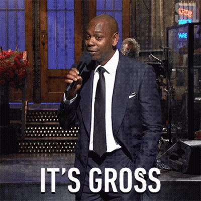 A Man In A Suit And Tie Is Holding A Microphone And Says It 'S Gross On The Bottom GIF