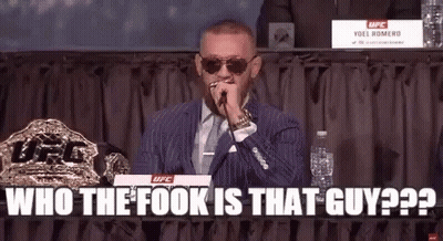 A Man In A Suit And Tie Is Holding A Microphone In His Mouth . GIF