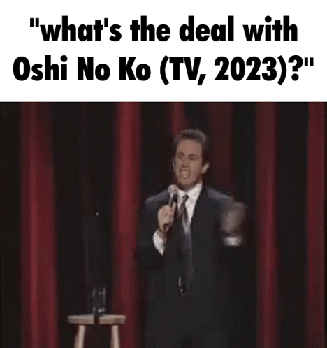 A Man In A Suit And Tie Is Holding A Microphone On A Stage . GIF