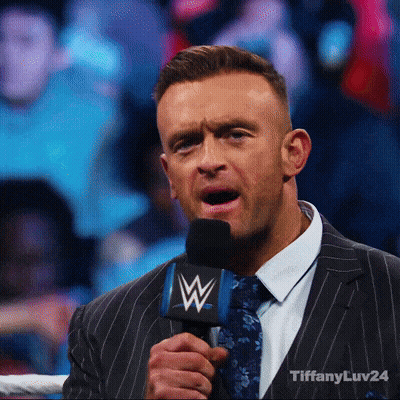 A Man In A Suit And Tie Is Holding A Microphone That Says Tiffanyluv24 GIF