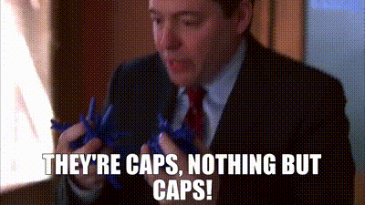 A Man In A Suit And Tie Is Holding A Pair Of Scissors And Says They 'Re Caps , Nothing But Caps GIF