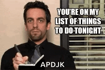 A Man In A Suit And Tie Is Holding A Pen And A Notebook . GIF