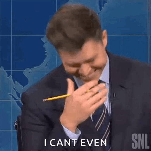 A Man In A Suit And Tie Is Holding A Pencil To His Mouth And Laughing . GIF