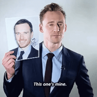 A Man In A Suit And Tie Is Holding A Picture Of Another Man And Saying This One 'S Mine . GIF