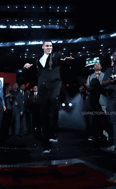 A Man In A Suit And Tie Is Holding A Piece Of Paper GIF