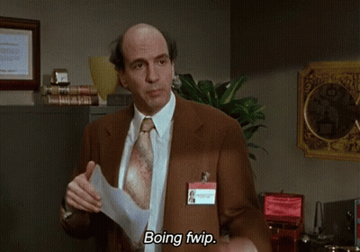 A Man In A Suit And Tie Is Holding A Piece Of Paper And Says Boing Fwip GIF