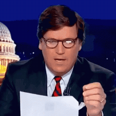 A Man In A Suit And Tie Is Holding A Piece Of Paper In Front Of The Capitol Building . GIF