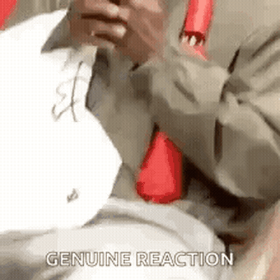 A Man In A Suit And Tie Is Holding A Piece Of Paper In His Hand And Says `` Genuine Reaction '' . GIF