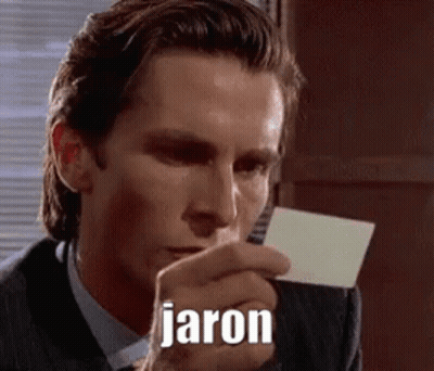 A Man In A Suit And Tie Is Holding A Piece Of Paper In His Hand With The Name Jaron Written On It . GIF