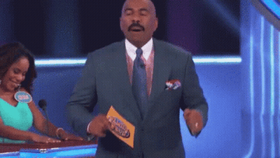 A Man In A Suit And Tie Is Holding A Piece Of Paper That Says Family Feud .. GIF