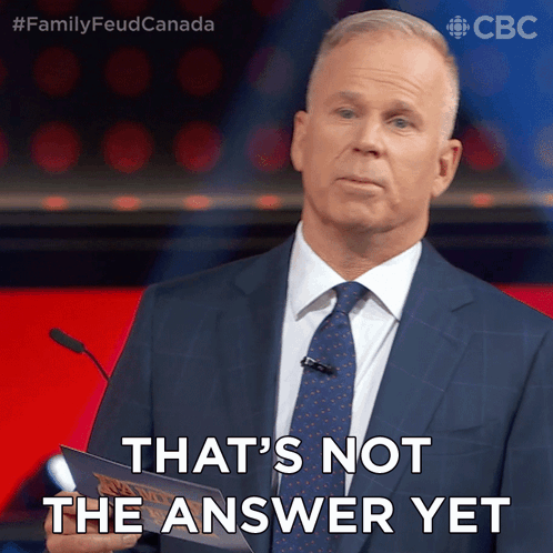 A Man In A Suit And Tie Is Holding A Piece Of Paper That Says " That 'S Not The Answer Yet " GIF