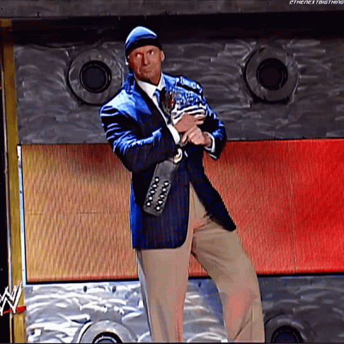 A Man In A Suit And Tie Is Holding A Trophy In Front Of A Wall That Says Ethenextbigthing GIF