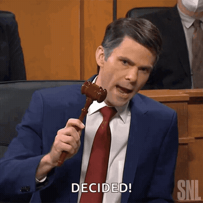 A Man In A Suit And Tie Is Holding A Wooden Gavel And Says " Decided " GIF