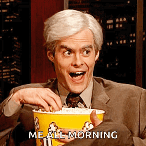 A Man In A Suit And Tie Is Holding A Yellow Bucket Of Popcorn And Says " Me All Morning " GIF